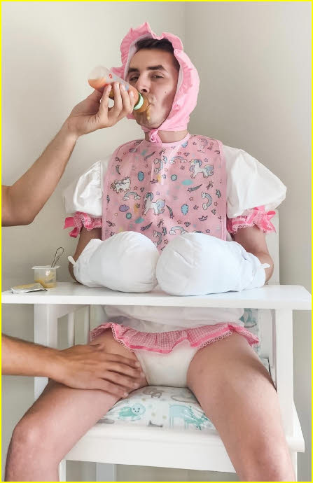 Adult baby DiaperKing in tragic pink bib and bonnet being bottle-fed by daddy Adult baby DiaperKing in tragic pink bib and bonnet being bottle-fed by daddy